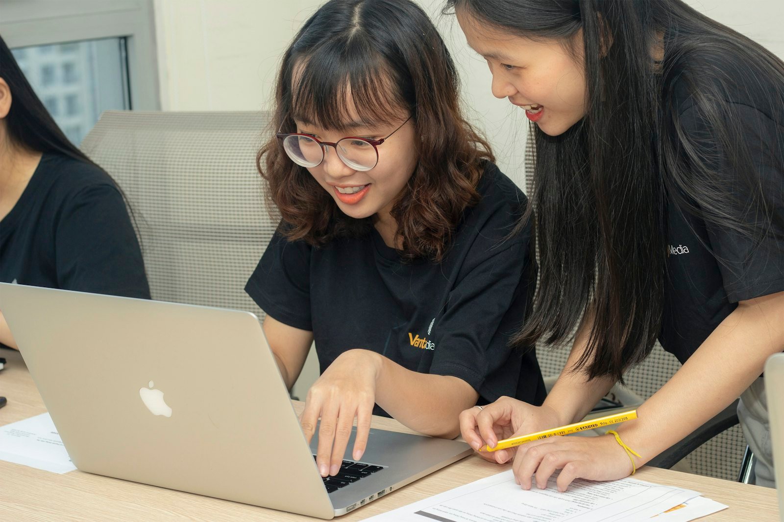 Two people working through code together on a laptop